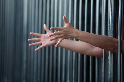 hands reaching through bars